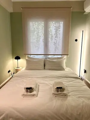 a bedroom with a large white bed with towels on it at Aura, Sis Urban Apartments III in Athens