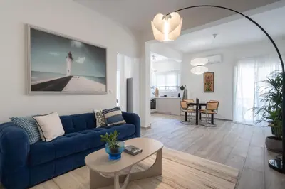 a living room with a blue couch and a table at 2BD Apt in Petralona Near Metro in Athens
