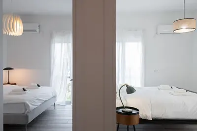 two beds in a bedroom with white walls at 2BD Apt in Petralona Near Metro in Athens