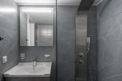 a bathroom with a sink and a shower with a mirror at 2BD Apt in Petralona Near Metro in Athens