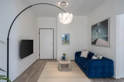 a living room with a blue couch and a tv at 2BD Apt in Petralona Near Metro in Athens
