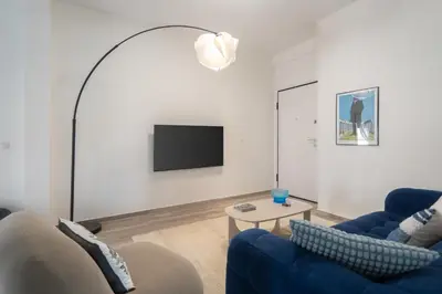 a living room with a blue couch and a tv at 2BD Apt in Petralona Near Metro in Athens
