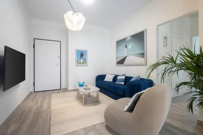 a living room with a blue couch and a tv at 2BD Apt in Petralona Near Metro in Athens