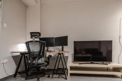 a desk with a computer and a chair and a television at Athenian Central Escape in Athens