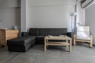 a living room with a couch and a table and a chair at Athenian Central Escape in Athens