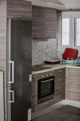 a kitchen with a stainless steel refrigerator and wooden cabinets at Athenian Central Escape in Athens
