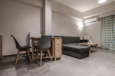 a living room with a couch and a table and chairs at Athenian Central Escape in Athens