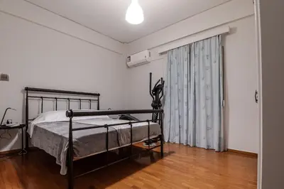 a bedroom with a bed and a large window at Athenian Central Escape in Athens