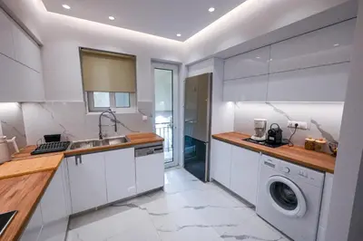 a kitchen with a sink and a washing machine at Koukaki Modern Living in Athens