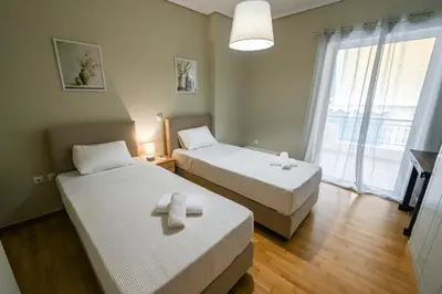 a hotel room with two beds and a window at Koukaki Modern Living in Athens