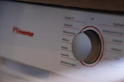 a close up of a washing machine with a red knob at Cozy Bright apartment next to Acropolis! in Athens