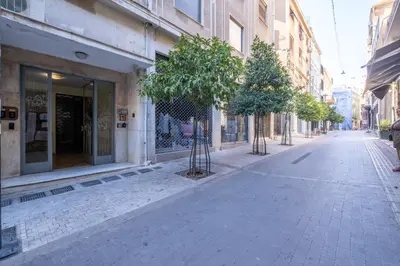 an empty street with trees on the side of a building at Cozy Bright apartment next to Acropolis! in Athens
