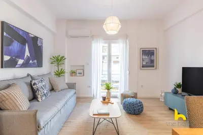 a living room with a couch and a tv at Bright, Central Hideaway Near Acropolis & Metro! in Athens