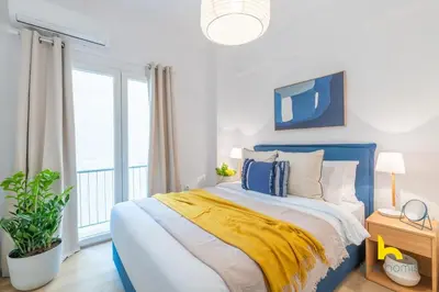 a bedroom with a blue bed with a yellow blanket at Bright, Central Hideaway Near Acropolis & Metro! in Athens