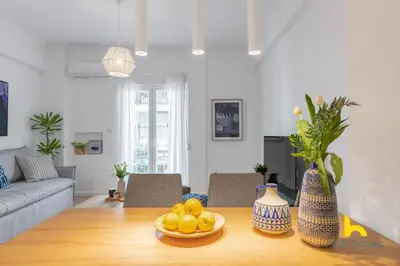 a living room with a table with fruit on it at Bright, Central Hideaway Near Acropolis & Metro! in Athens
