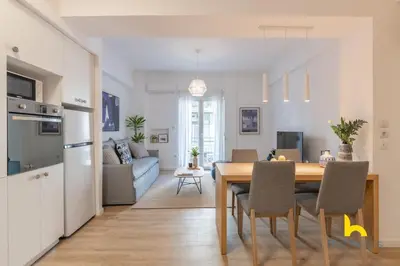 a kitchen and living room with a table and chairs at Bright, Central Hideaway Near Acropolis & Metro! in Athens