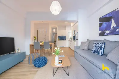 a living room with a couch and a table at Bright, Central Hideaway Near Acropolis & Metro! in Athens