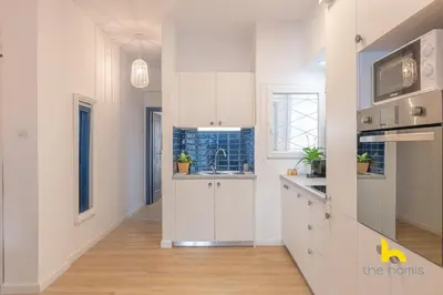 a kitchen with white cabinets and a sink at Bright, Central Hideaway Near Acropolis & Metro! in Athens