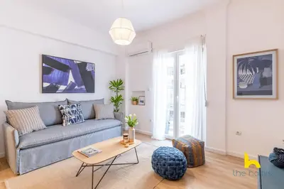 a living room with a couch and a table at Bright, Central Hideaway Near Acropolis & Metro! in Athens