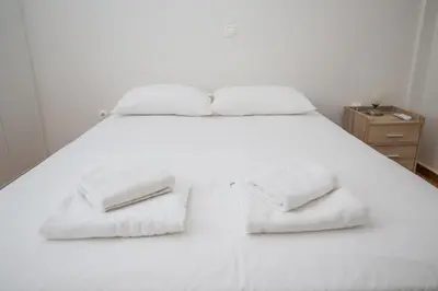 a white bed with white towels on it at Spacious 3 Bedroom Apartment With Large Balcony in Athens