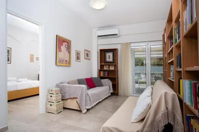 a living room with a couch and book shelves at Spacious 3 Bedroom Apartment With Large Balcony in Athens
