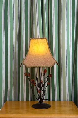 a lamp sitting on top of a table with flowers at Spacious 3 Bedroom Apartment With Large Balcony in Athens