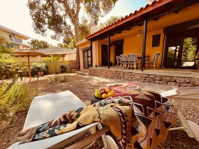 a patio with a table and chairs in front of a house at Garden House 2 Bedroom Suite in Vari