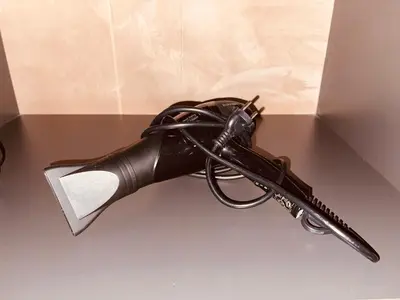 a black gun is sitting on a table at Garden House 2 Bedroom Suite in Vari