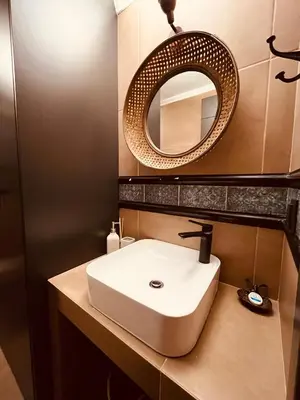 a bathroom with a white sink and a mirror at Garden House 2 Bedroom Suite in Vari