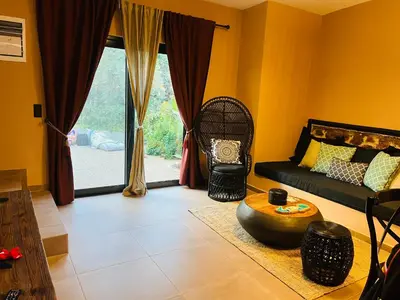 a living room with a couch and a table at Garden House 2 Bedroom Suite in Vari