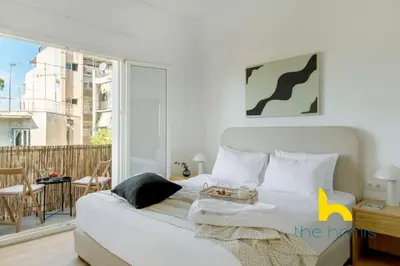 a bedroom with a white bed and a balcony at Modern Athens Stay - 2BR with Balcony, Steps to Metro in Athens