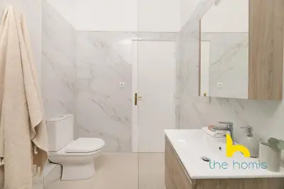 a white bathroom with a toilet and a sink at Modern Athens Stay - 2BR with Balcony, Steps to Metro in Athens