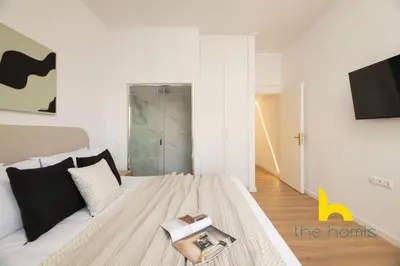 a bedroom with a bed with a book on it at Modern Athens Stay - 2BR with Balcony, Steps to Metro in Athens