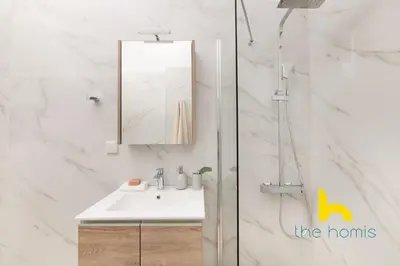 a white bathroom with a sink and a mirror at Modern Athens Stay - 2BR with Balcony, Steps to Metro in Athens