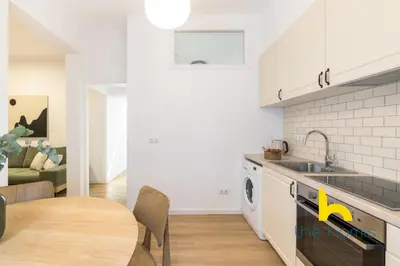 a kitchen and dining room with a table and a sink at Modern Athens Stay - 2BR with Balcony, Steps to Metro in Athens