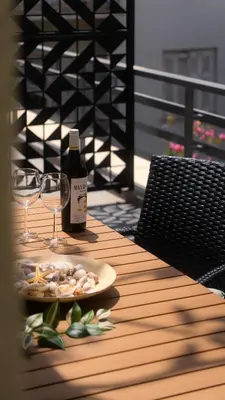 a bottle of wine and a plate of food on a table at Stylish apartment with large terrace in Athens