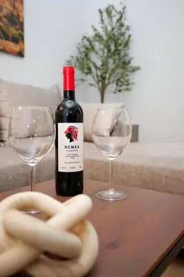 a bottle of wine and two wine glasses on a table at Two Bedroom Flat In Athens in Athens