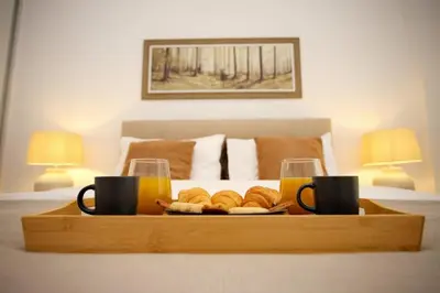 a tray with a plate of bread and two cups of orange juice at Two Bedroom Flat In Athens in Athens