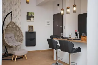 a room with a bar with chairs and a hanging chair at Two Bedroom Flat In Athens in Athens