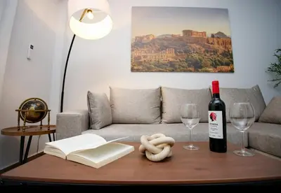 a living room with a bottle of wine and a table at Two Bedroom Flat In Athens in Athens