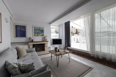 a living room with a white couch and a fireplace at Wake Up to the Acropolis in a Hidden Gem in Athens