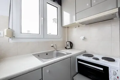 a white kitchen with a sink and a stove at Wake Up to the Acropolis in a Hidden Gem in Athens