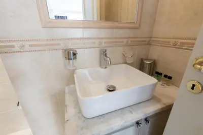a white sink in a bathroom with a mirror at Wake Up to the Acropolis in a Hidden Gem in Athens