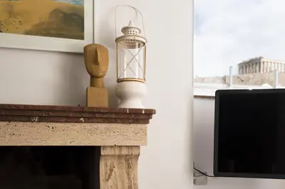 a fireplace with a candle on top of it at Wake Up to the Acropolis in a Hidden Gem in Athens