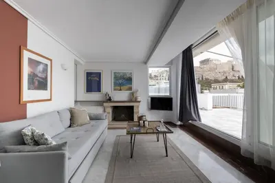 a living room with a white couch and a fireplace at Wake Up to the Acropolis in a Hidden Gem in Athens