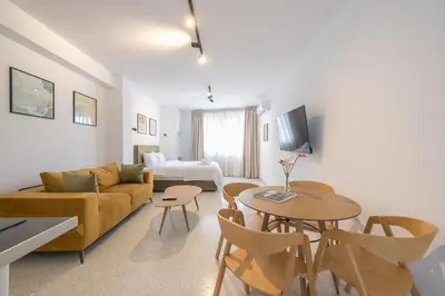 a living room with a couch and a table at Spacious Couples Studio with Seating Area & Rooftop Vibes Zen Gaia By Tessera in Athens