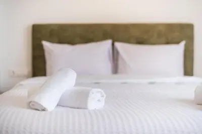 a stack of rolled towels on a bed at Spacious Couples Studio with Seating Area & Rooftop Vibes Zen Gaia By Tessera in Athens