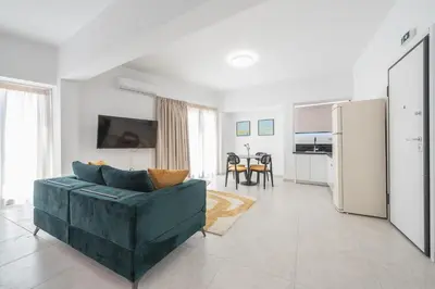 a living room with a green couch and a kitchen at Penthouse Zen Harmonia By Tessera in Athens