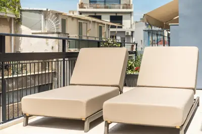 two white chairs sitting on a balcony at Penthouse Zen Harmonia By Tessera in Athens