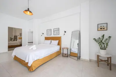 a bedroom with a large bed and a mirror at Penthouse Zen Harmonia By Tessera in Athens